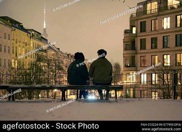 09 February 2021, Berlin: Two people are sitting on a bench in the dark. Photo: Annette Riedl/ZB-Zentralbild/ZB. - Berlin/Berlin/Germany