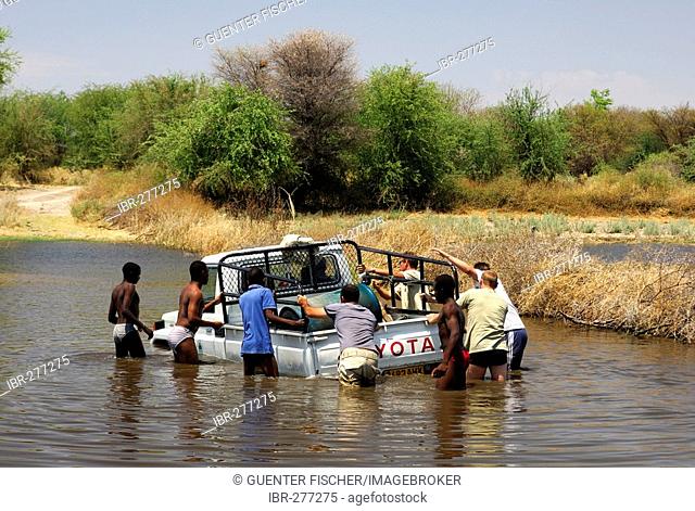 Four-wheel drive jeep booged down while crossing a river, teamwork, Botswana, Africa