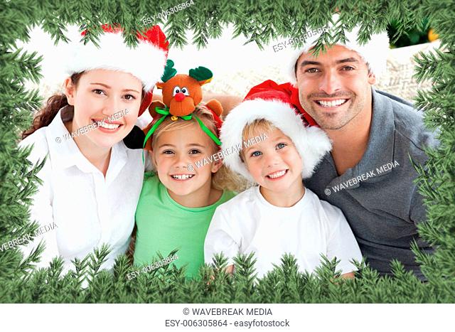 Happy family with christmas hats sitting on the sofa