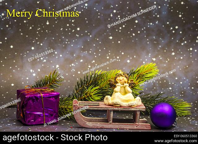 angel on sledge with night sky background and Merry Christmas text