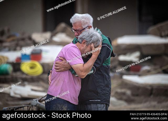 19 July 2021, Rhineland-Palatinate, Altenahr: Two brothers weep in each other's arms in front of their parents' house, which was destroyed by the flood