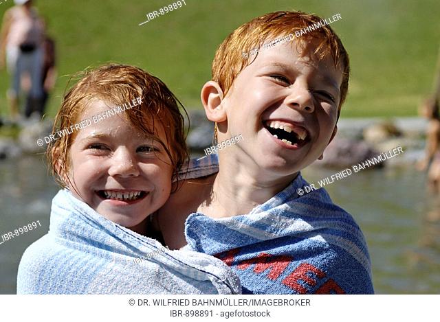 Children wrapped up in a towel after swimming