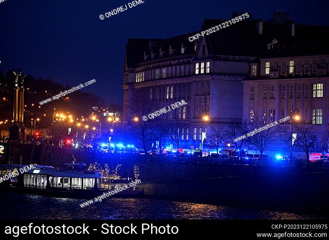 Ambulances and police at Dvorak Embankment, where shots were fired in the Faculty of Arts building (in background), in Prague, Czech Republic, on December 21