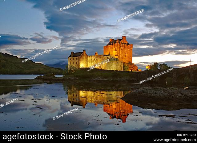 Das angestrahlte Castle Eilean Donan spiegelt sich im Wasser des Loch, blaue Stunde, Filmkulisse, Dornie, Highlands, Schottland, Großbritannien