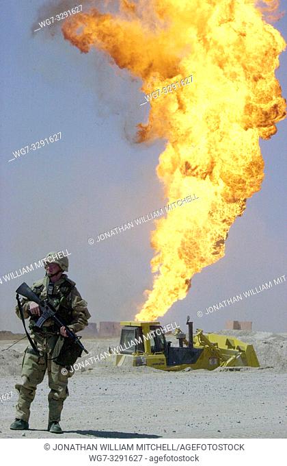 IRAQ Rumaylah Oil Field - 02 Apr 2003 - A US Army soldier stands guard duty near a burning oil well in the Rumaylah Oil Fields in southern Iraq