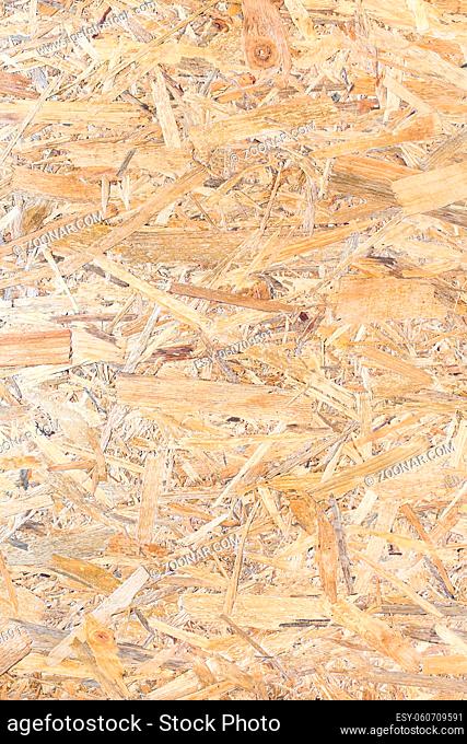 OSB panel texture. Oriented Strand Board. Chipboard building material. OSB wooden panel made of pressed sandy brown wood shavings as background closeup