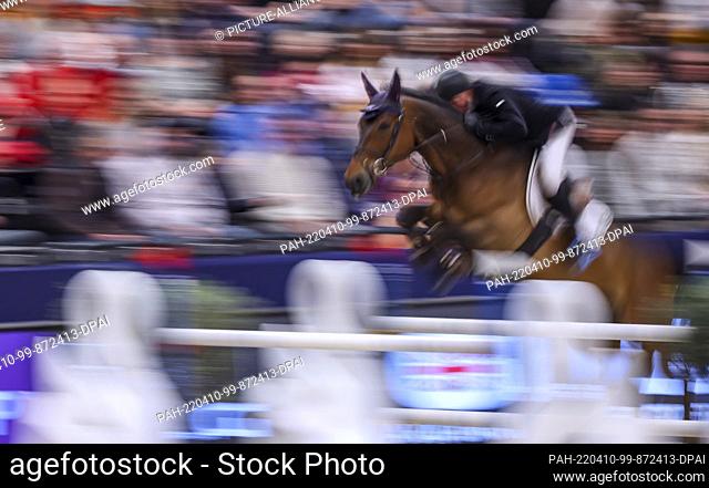 10 April 2022, Saxony, Leipzig: John Whitaker of Great Britain rides Equine America Unick du Francportim Final in the Longines Fei Jumping World Cup at the...