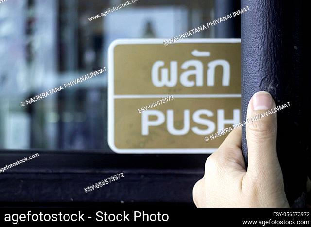 Hand on opening into store door, stock photo