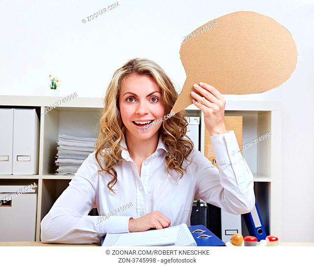 Geschäftsfrau mit leerer Sprechblase aus Pappe in ihrer Hand im Büro