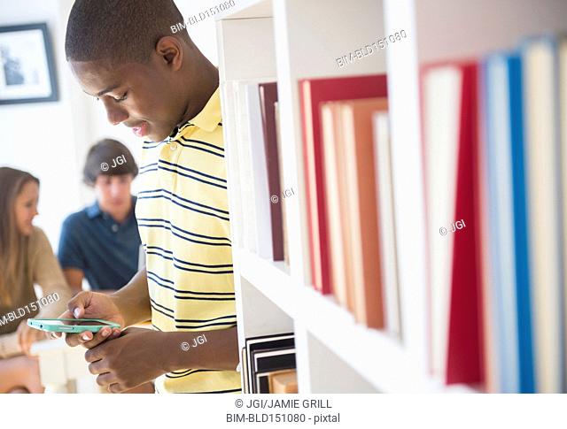Teenage boy using cell phone at party