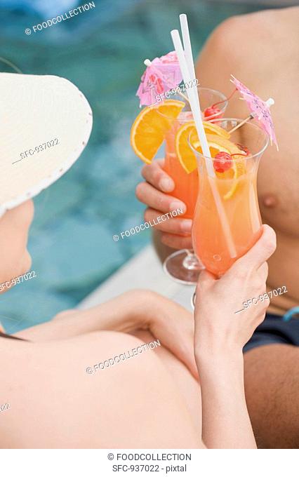 Man and woman clinking glasses of Planter's Punch