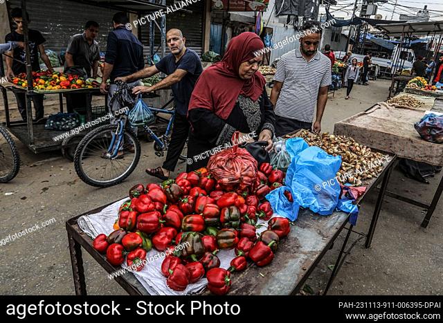 13 November 2023, Palestinian Territories, Rafah: Palestinians buy food supplies from a market in Rafah in the southern Gaza Strip