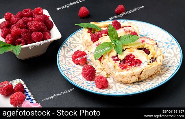 Baked meringue roll with cream and fresh red raspberry, delicious dessert