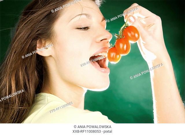 Young woman eating cherry tomatoes