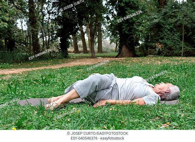 elderly woman practicing yoga outdoors