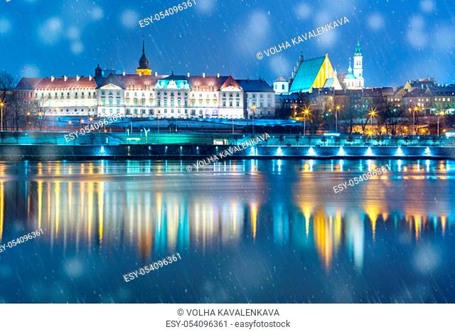 Old Town with reflection in the Vistula River during snowy evening blue hour, Warsaw, Poland