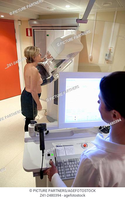 Radiology technician performs mammography test by xray