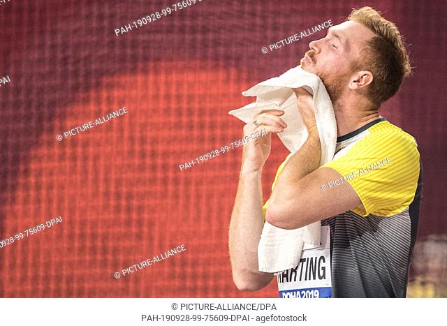 28 September 2019, Qatar, Doha: Athletics, IAAF World Championships at Khalifa International Stadium: Diskus, Men, Christoph Harting from Germany wipes off...