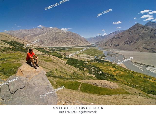 Man enjoying the view over the mountain landscape of Langar, Wakhan Corridor, Tajikistan, Central Asia