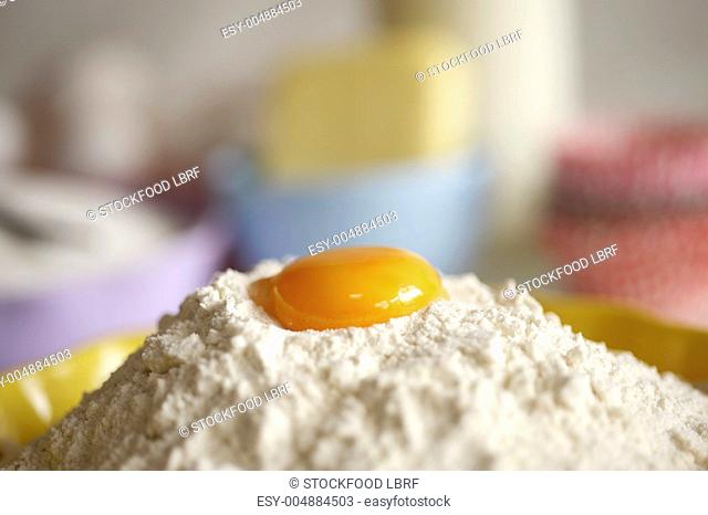 An egg yolk on top of a pile of flour