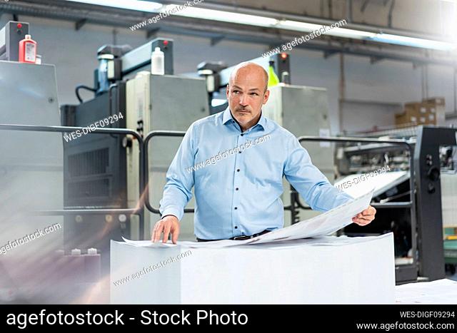 Businessman in a printing plant looking around