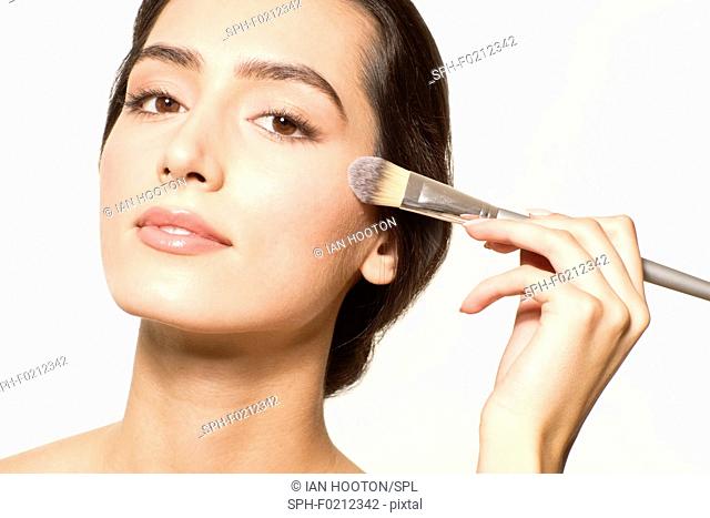 Woman applying foundation with brush
