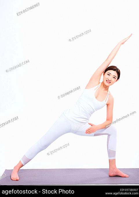 Young women practice yoga with white sportswear standing on the yoga mat