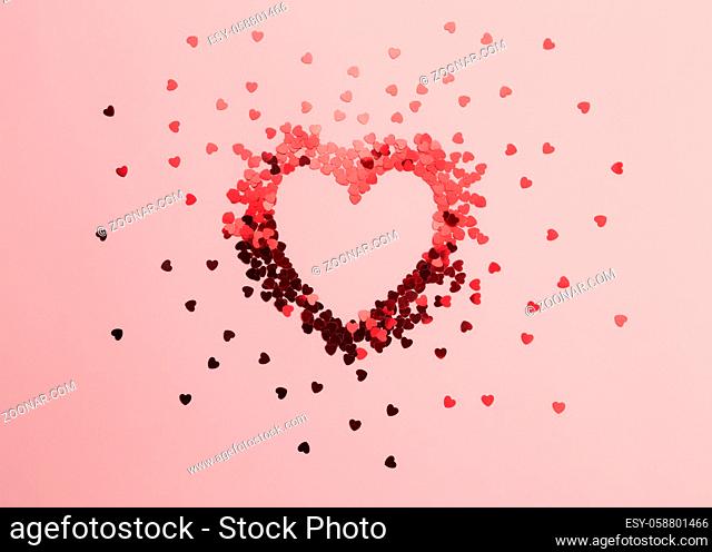 Red heart glitters on the pink background. High quality photo