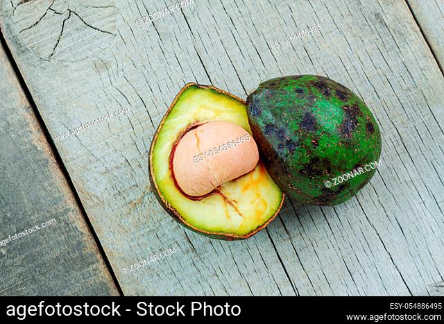 Avocado cut of half and stacked on the old wooden floor