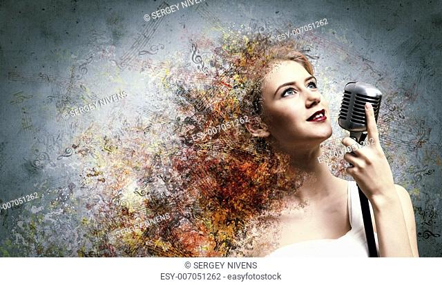 Image of female blondD3 singer holding microphone against color background