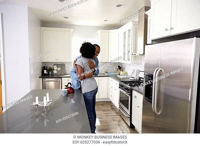 Young Couple Hugging In Apartment Kitchen