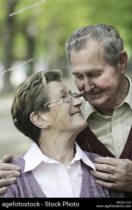 Germany, Cologne, Senior couple looking at each other in park, smiling