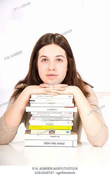 Teenage girl thinking over pile of books, overworked