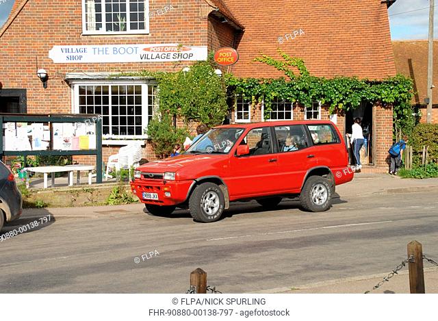Children in 4x4, after being picked up from village school, outside shop and post office, Long Marston, Hertfordshire, England