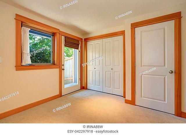 Empty simple entryway in apartment house. Carpet flooring, built-in closet and brown wooden trim. Northwest, USA