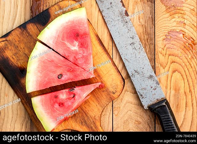 watermelon and old knife on the wooden table