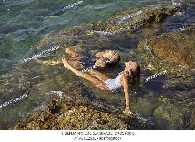 Two young women relaxing on water. Chersonissos, Crete, Greece