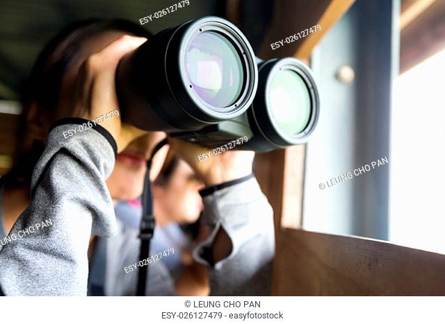 Asian Woman use of the binoculars for birdwatching