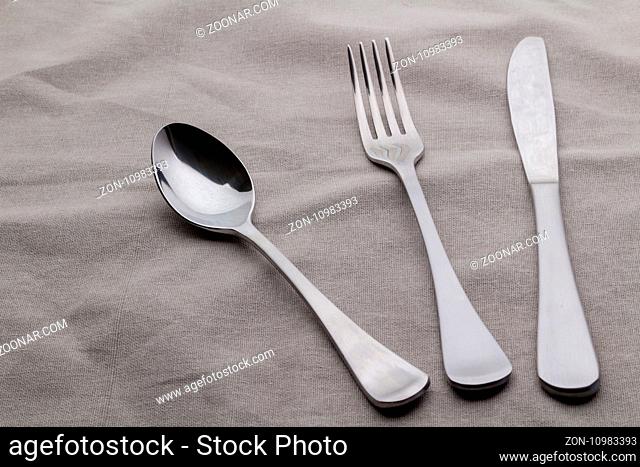 Cutlery set with spoon, fork and knife on tablecloth close up photo - Background with space for text
