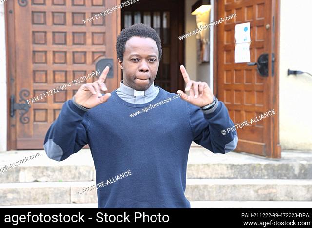 PRODUCTION - 19 December 2021, Thuringia, Weimar: Jean-Francois Uwimana, a priest from Rwanda, raps the Gospel in front of St. Boniface Church