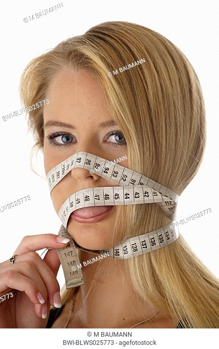 young woman wrapping measuring tape around her head