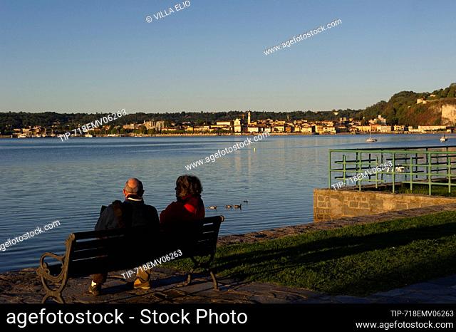 Europe, Italy, Lombardy, Varese, Lake Maggiore, Angera lakefront with couple on the bench