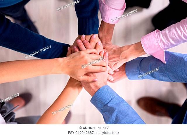 An Elevated View Of Businesspeople Stacking Hands Over Each Other