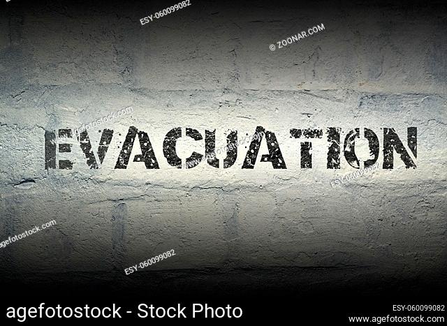 evacuation stencil print on the grunge white brick wall