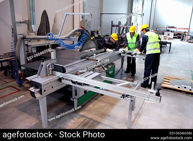 Group of industrial factory workers working with CNC machine