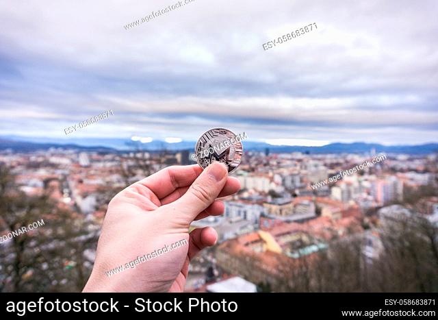 Photo of Monero silver coin, Hand holding Monero on top of the world