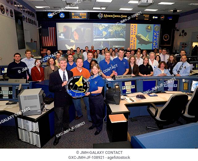 The members of the STS-120 Ascent flight control team and the flight's crewmembers pose for a group portrait in the space shuttle flight control room of...