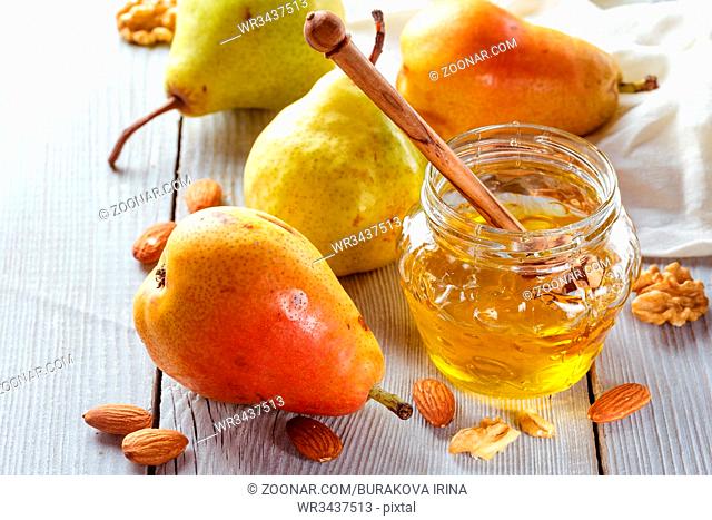 Tasty pears with honey and nuts on wooden table