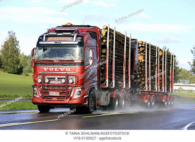 SALO, FINLAND - SEPTEMBER 22, 2018: Red Volvo FH16 750 logging truck of Kuljetusliike Seppo Saarinen transports log load on wet road in autumn