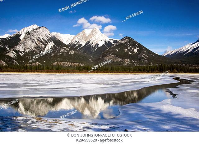 DeSmet Range reflected in open ice and water channel of Jasper Lake. Alberta, Canada